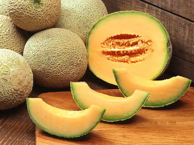 Whole cantaloupes with netted rinds beside slices of orange flesh.